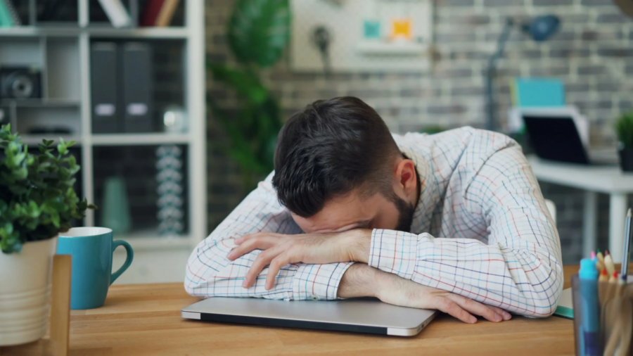 Homme épuisé en journée, illustrant la fatigue diurne causée par les signes de l'apnée du sommeil.