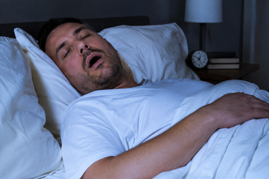 Un homme dormant paisiblement sur le dos, illustrant une nuit sans ronflements.