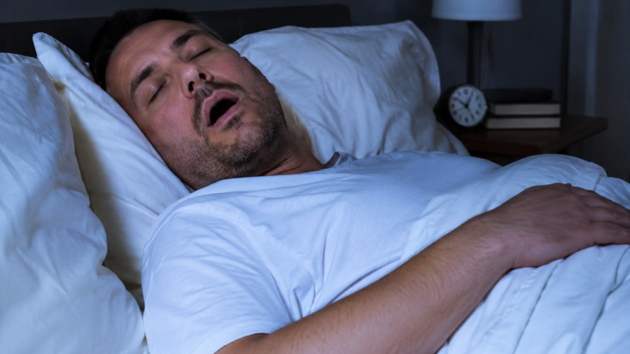 Un homme dormant paisiblement sur le dos, illustrant une nuit sans ronflements.