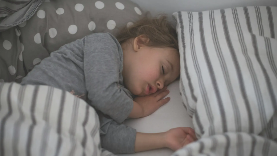 Enfant dormant paisiblement dans son lit après une consultation pour un trouble du sommeil